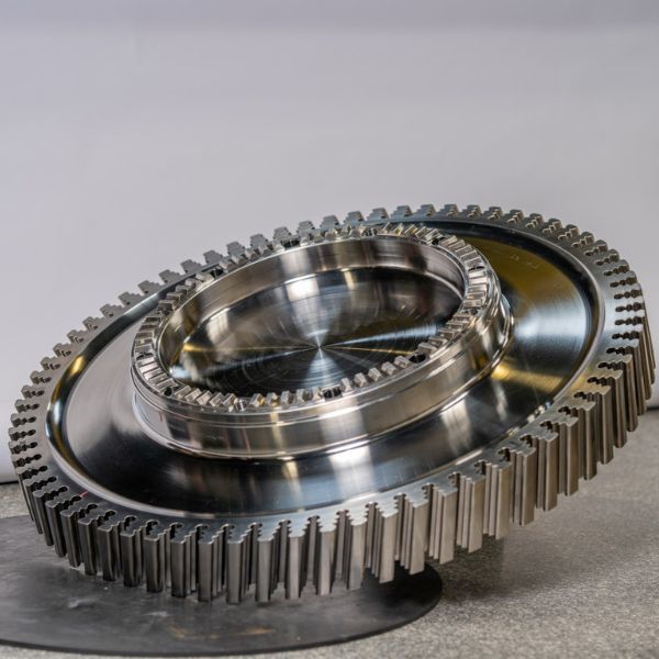 A precision-machined steam or gas turbine disk featuring intricate firtree blade attachment slots.
